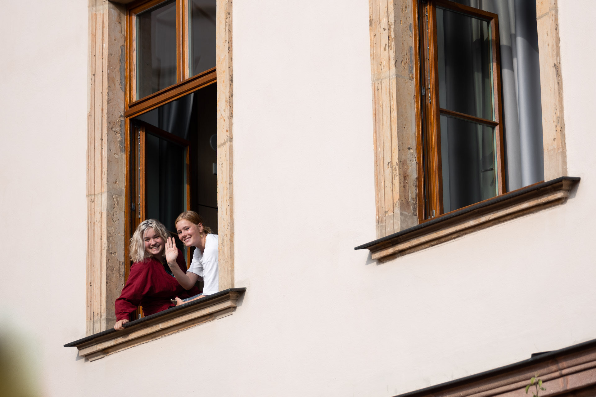 Zwei Mädchen schauen aus einem Fenster. 